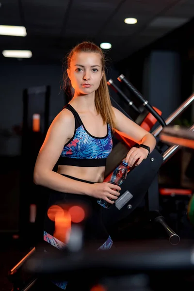 Fit pretty lady at gym. Young strong charming girl in sportswear.
