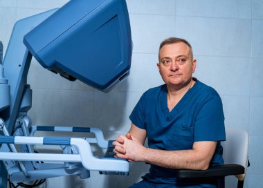 Doktor büyük bir röntgen makinesinin önünde oturuyor..