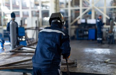 İşçi fabrikadaki metal yapısını kaynaklıyor..