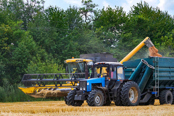 Синий трактор и желтый комбайн собирают пшеницу I