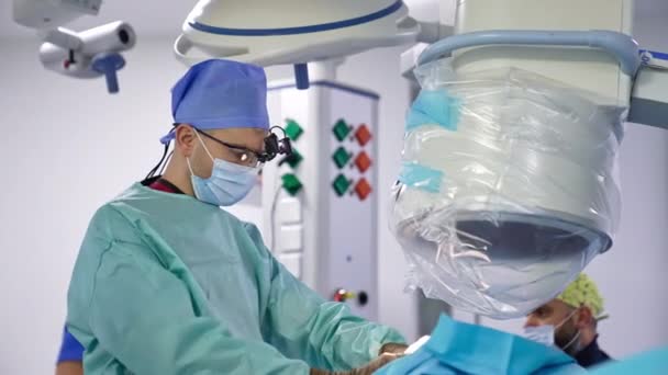 Νευροχειρουργός Κιάλια Φακό Εκτελεί Την Επέμβαση Βοηθός Δίνει Ένα Σφουγγάρι — Αρχείο Βίντεο