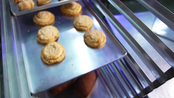 美味新鲜的烤好的糕点放在烤盘上 甜甜的甜点在面包店生产 靠近点 — 图库视频影像
