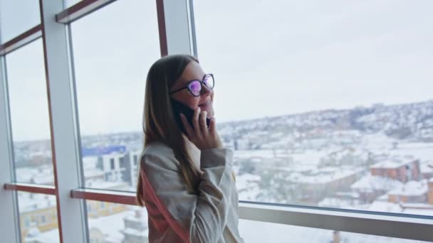 Bizneswoman Rozmawia Przez Telefon Stojąc Przy Oknie Uśmiechnięta Dama Rozmawiająca — Wideo stockowe