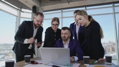 İşbirliği ekibi yönetim kurulu başkanının etrafında toplandı. Bilgisayarın merkezindeki adam tartışmak için fikirler öneriyor. Bir çalışan telefona cevap veriyor. Yavaş yavaş mesafeyi kapat.