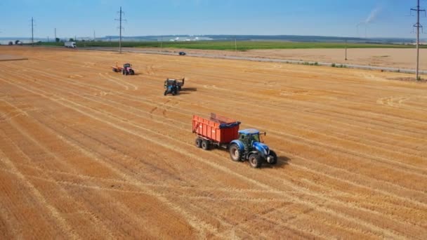 農業プランテーションで移動するトラクターマシン バックグラウンドで干し草バレルでアップロードされているトラック — ストック動画