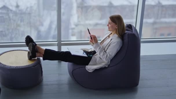 Jovem Relaxada Senta Cadeira Feijão Esticando Pernas Para Mesa Café — Vídeo de Stock