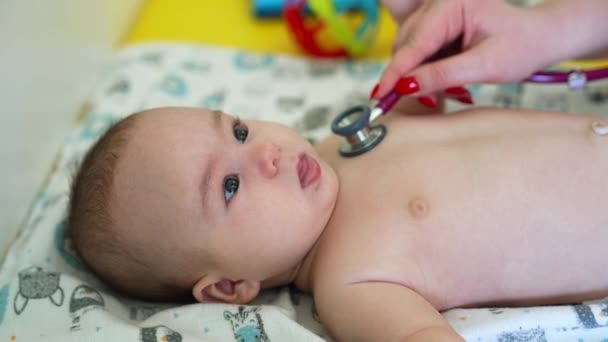 의사는 아기의 가슴에 스테로스코프를 넣고있다 아이는 달콤하게 미소를 지으며 의사에게 — 비디오