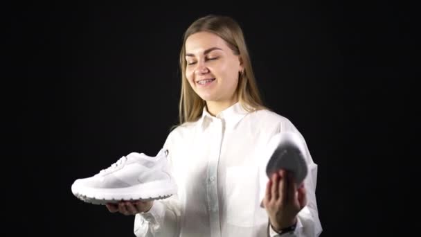 Lady White Shirt Holds White Sneakers Different Pairs Both Hands — Stock Video
