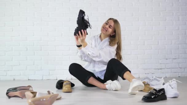 Radosna Młoda Kobieta Siedząca Podłodze Pokazująca Różne Obuwie Prezentacja Butów — Wideo stockowe