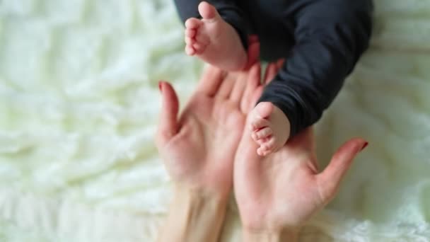 妈妈抱着娇嫩的小脚 爱抚它们 爱妈妈触摸她孩子的小脚趾 靠近点 — 图库视频影像