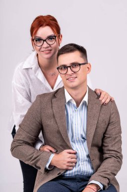 Genç çift sandalyede oturuyor ve gülümsüyor..