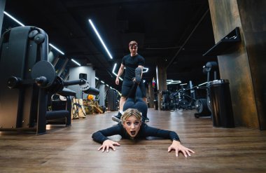 Spor salonunda halatla şınav çeken genç adam.