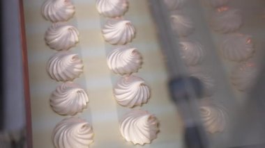 Taze vanilyalı zephyr tatlılar konveyör hattında. Modern gıda fabrikasında lokum üretimi. Kapatın. Üst görünüm.