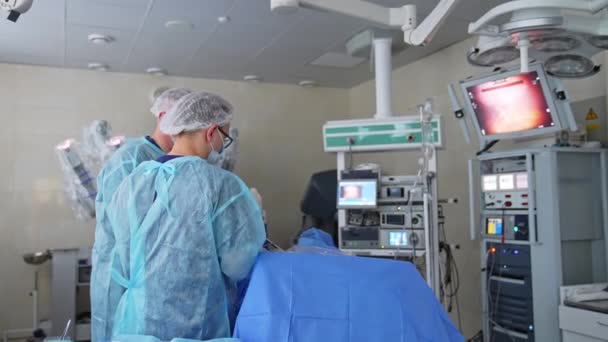 Dwóch Chirurgów Nowoczesnej Sali Operacyjnej Włączonym Ekranem Roboczym Monitor Pokazuje — Wideo stockowe