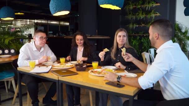 사무실 동료들은 직장에서 휴식하는 점심을 먹는다 테이블에서 카페에서 피자를 즐기는 — 비디오