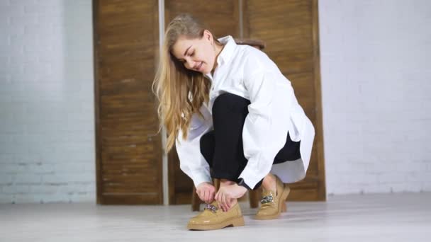 Sarışın Uzun Saçlı Bayan Şık Ayakkabılarına Dokunmak Için Çömeldi Model — Stok video