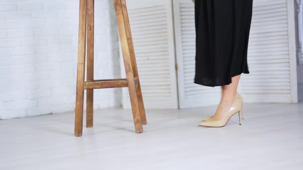 Biała Kobieta Beżowych Szpilkach Podchodzi Drewnianego Tabouretu Modelka Podnosi Nogę — Wideo stockowe