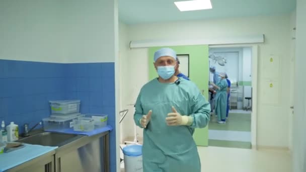 手術の準備ができている外科医は手術室に行きます 男性の医療専門家は彼の目の前で手袋の手を保持し 何も触れない — ストック動画
