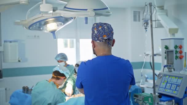 Anestesista Sta Con Spalle Alla Telecamera Guardare Operazione Squadra Chirurghi — Video Stock