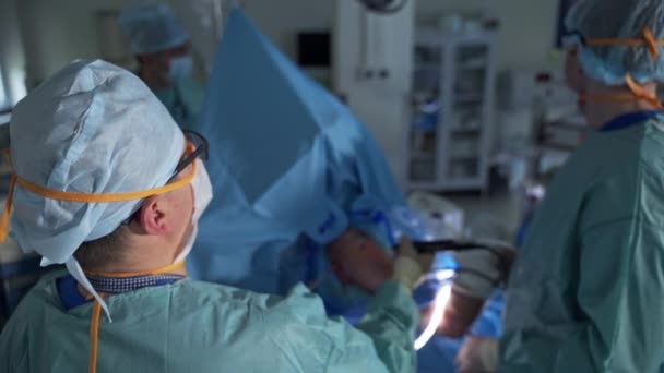 Chefskirurg Håller Och Flyttar Apparaten Inmatning Patientens Kropp Medicinskt Team — Stockvideo