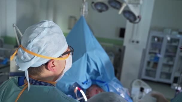成年外科医生将设备工具输入移入病人体内 高角镜 背景模糊的手术室 — 图库视频影像