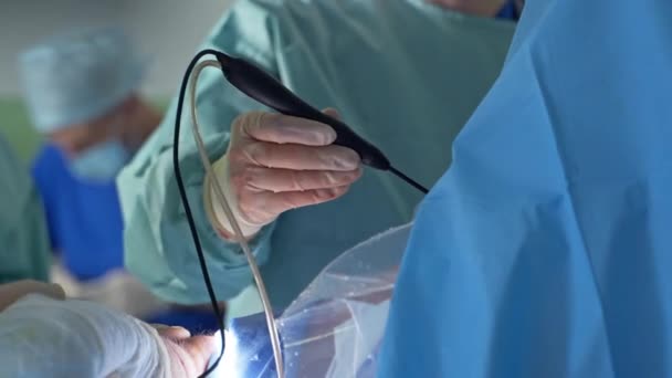 外科医生戴着手套的手拿着装有管子的黑色器械 医学专家把电器设备输入病人体内 — 图库视频影像