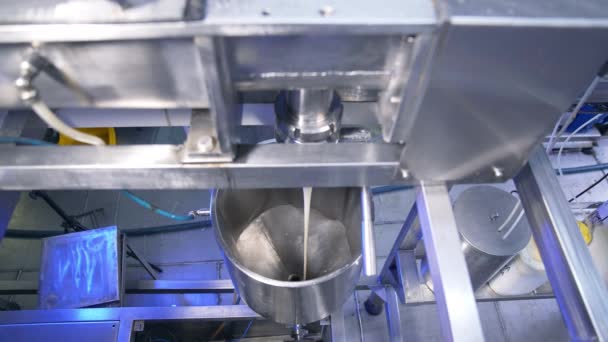 厚いクリーミーな凝縮されたミルクは パイプから金属タンクに注がれています 食品工場の菓子生産ライン — ストック動画