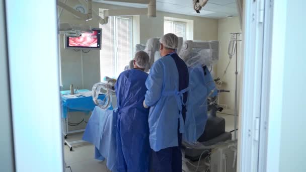 Dua Dokter Bedah Pria Bekerja Ruang Operasi Dekat Robot Vinci — Stok Video