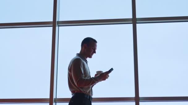 Yakışıklı Genç Adam Telefona Bakıyor Gülümsüyor Öğle Arasında Panoramik Pencerenin — Stok video