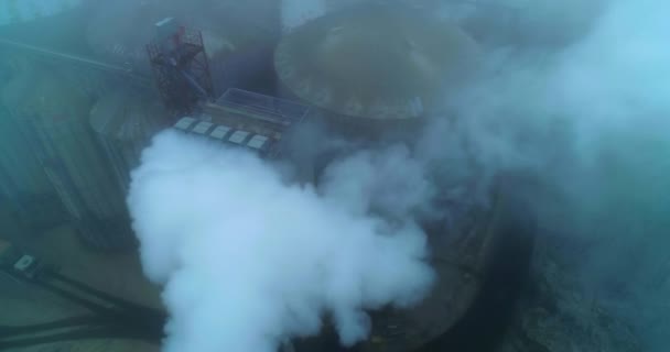 用于谷物储存和加工的大型农业综合企业工厂 在白烟和雾中的筒仓房顶俯瞰 — 图库视频影像