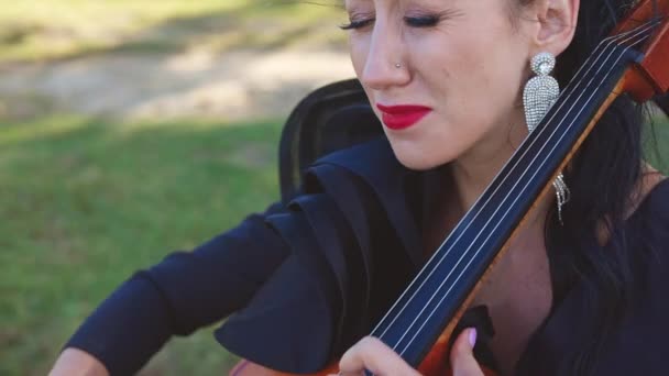 浓妆艳抹的女人在感情上弹奏古典音乐 在大自然的背景下弹奏大提琴 — 图库视频影像
