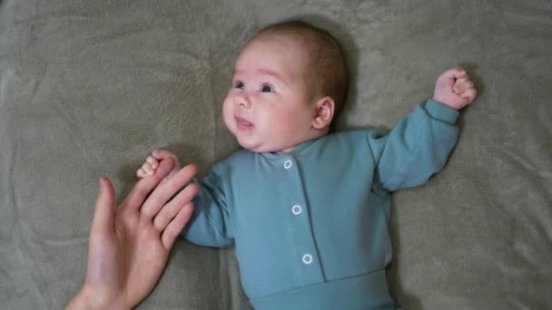 Söt Nyfödd Bebis Blå Kostym Ligger Sängen Håller Föräldrarnas Finger — Stockvideo