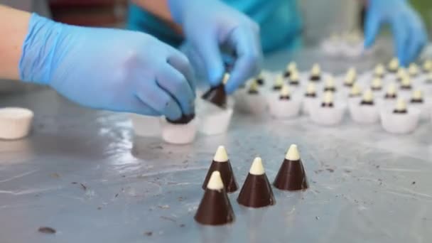 Şekerci Beyaz Bluzlu Küçük Çikolatalı Konileri Alıp Kağıda Döküyor Fabrikada — Stok video