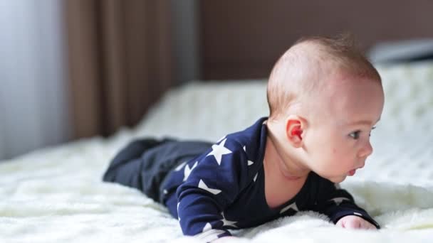 태어난 아기는 바라보는 퍼즐을 보인다 아름다운 소년은 머리를 누워있다 — 비디오