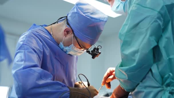 Doktor Kafasını Alet Gözlükleriyle Hastanın Üzerine Eğdi Cerrahların Kullandığı Elektrikli — Stok video