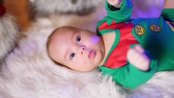 Zdrowe Dziecko Zielonym Kostiumie Elfa Leży Białej Kratce Machając Małymi — Wideo stockowe