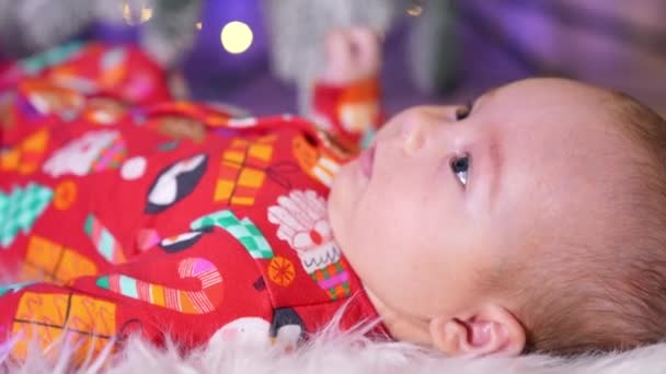 Kırmızı Noel Elbiseli Tatlı Çocuk Kameranın Karşısında Yatıyor Tombul Yanaklı — Stok video