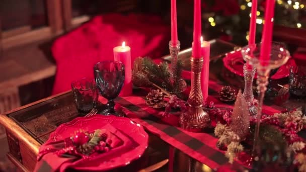装饰精美的桌子准备庆祝圣诞节 假盘子 玻璃杯和烛台 圆锥和红色浆果 — 图库视频影像