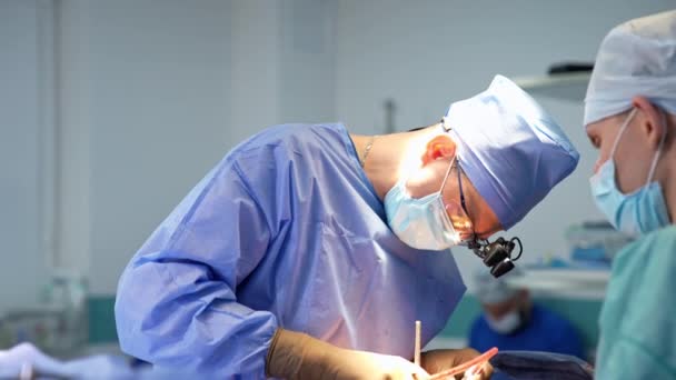 Neurochirurg Przeprowadzający Operację Klinice Asystentka Uważnie Obserwująca Zabieg Zamazane Tło — Wideo stockowe