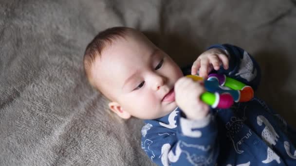 Uroczy Chłopczyk Jasną Zabawką Rękach Słodkie Dziecko Patrząc Zabawkę Uważnie — Wideo stockowe