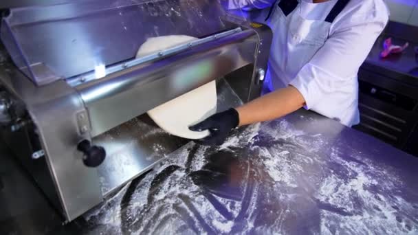 拉维奥生产过程中的面团扁平机 食品制造厂工人的手把糕点从压路机上拉出来 — 图库视频影像