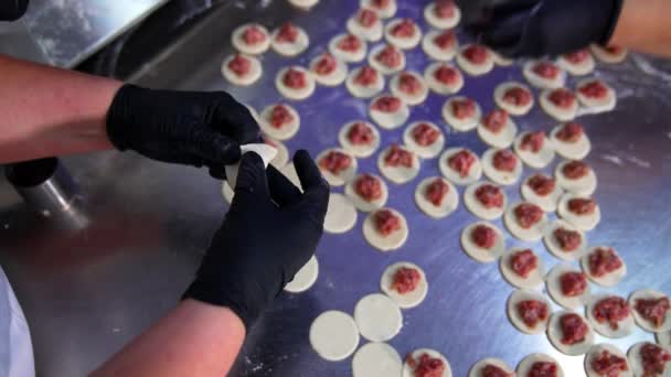 食品制造厂的厨师手工做饺子 金属桌上有切碎的面团和切碎的肉的圆形 顶部视图 — 图库视频影像