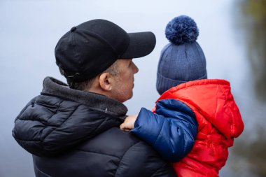 Baba ve oğlu göle bakıyor.