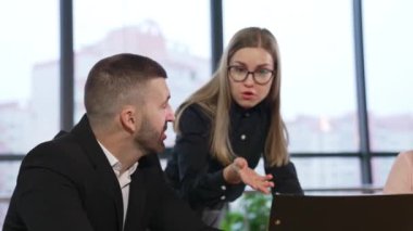 Genç bayan çalışan, meslektaşlarını evraklara işaret etmeye ikna ediyor. Büyük bir ofiste fikirleri tartışıp önerilerde bulunuyorlar..