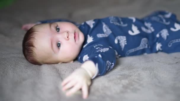 Toddler Boy Lies Grey Plaid Looking Camera Sweet Child Smiles — Stock Video