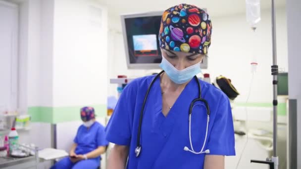 Pielęgniarka Śmiesznym Kolorowym Kapeluszu Masce Asystująca Przy Operacji Mężczyzna Lekarz — Wideo stockowe