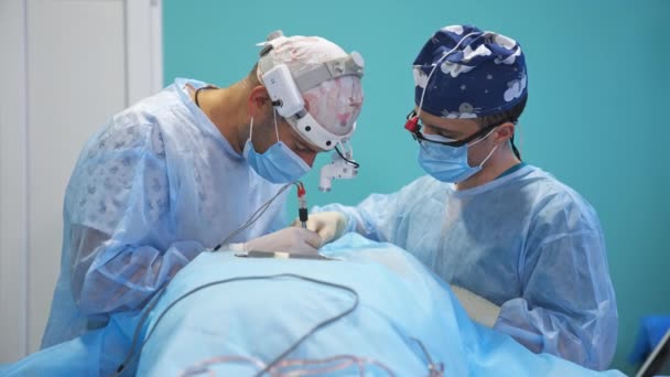 Два Хирурга Заняты Совместным Оперированием Пациента Врачи Фонариками Голове Выполняют — стоковое видео