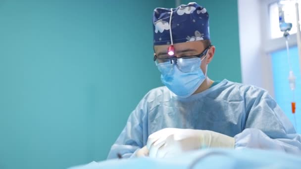 Молодой Врач Заканчивает Хирургическую Операцию Крупный План Портрета Хирурга Выполняющего — стоковое видео