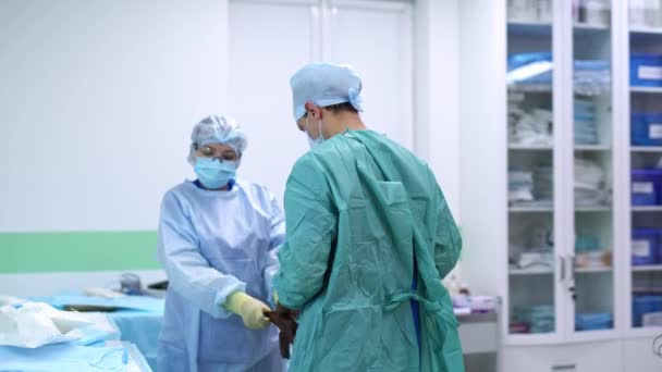 Молодой Хирург Одевается Операции Медсестра Помогает Доктору Надеть Перчатки Пальто — стоковое видео