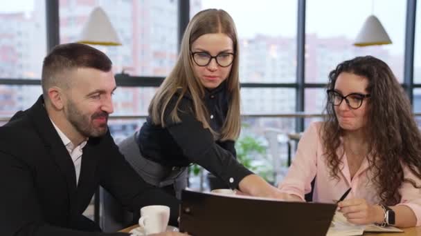 在美丽宽敞的办公室里进行富有成效的团队合作 长发女士靠着桌子站在那里 评论老板手中的文件 — 图库视频影像
